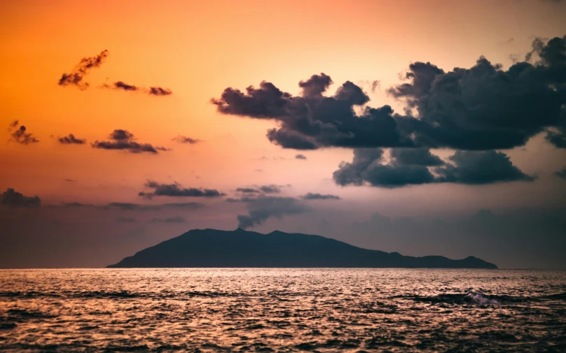 a sunset over the ocean with a small island in the distance, unsplash contest winner, romanticism, view from the sea, thumbnail, mediterranean island scenery, conde nast traveler photo