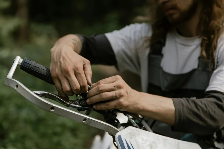 a close up of a person on a motorcycle, by Jacob de Heusch, repairing the other one, outdoor photo, avatar image, action sports