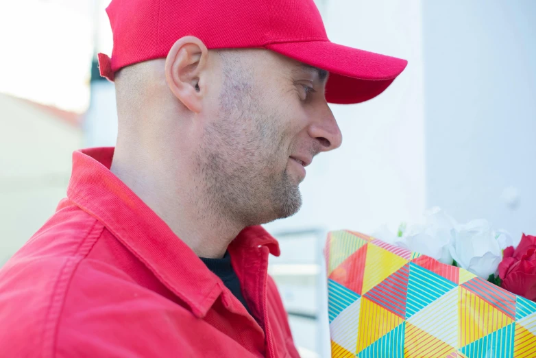 a man in a red hat holding a gift, pexels contest winner, karim rashid, avatar image, milkman, close - up profile