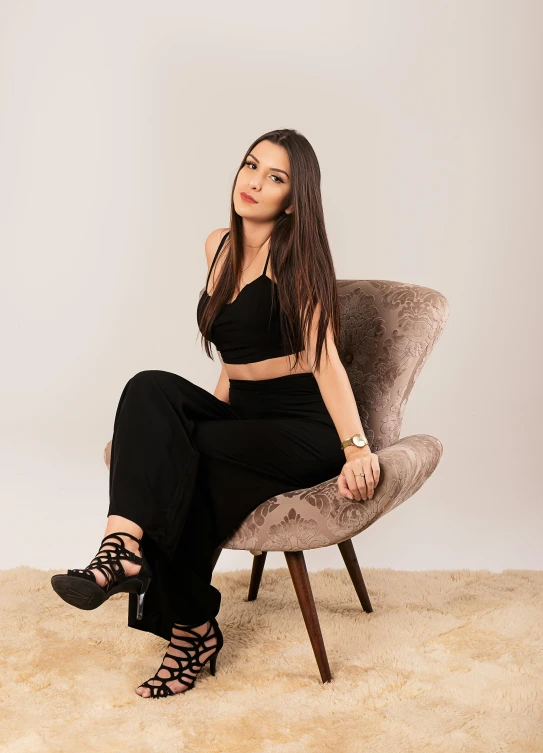 a woman sitting on a chair in a room, wearing black camisole outfit, profile image, trending photo, avatar image