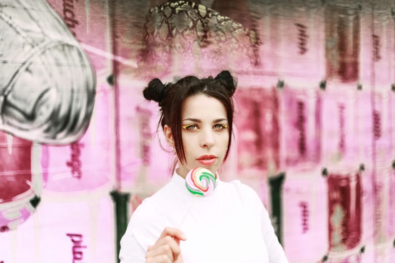 a woman in a white shirt holding a lollipop, an album cover, inspired by Elsa Bleda, pexels contest winner, pigtails hairstyle, kailee mandel, in an urban setting, bubblegum face