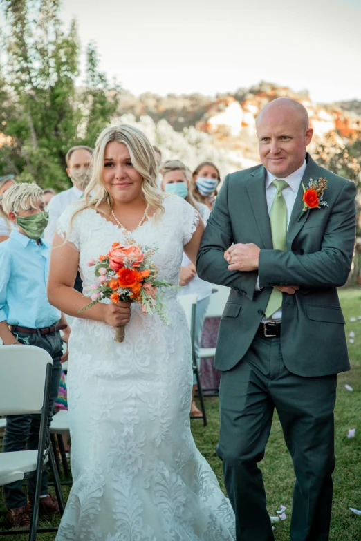 a bride and groom walking down the aisle, green and orange theme, photo of a woman, overlooking, smirking