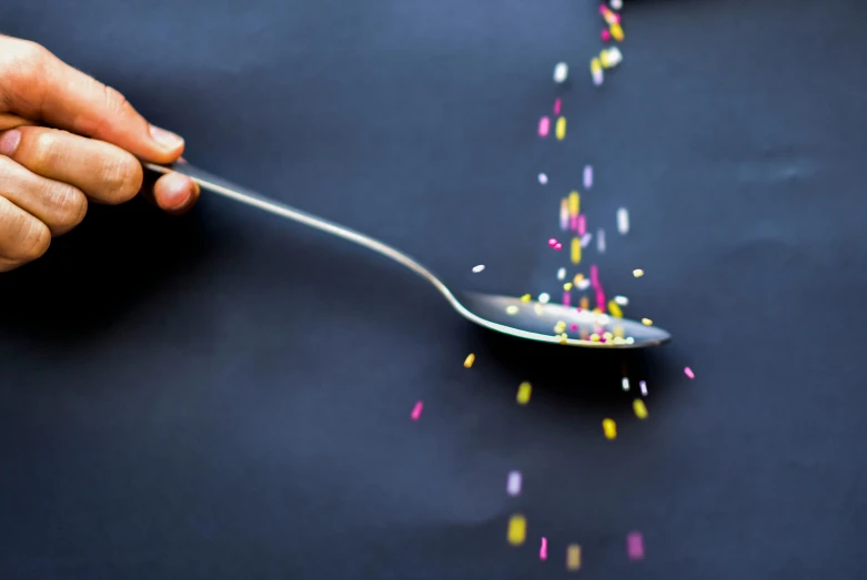 a spoon with sprinkles coming out of it, pexels, kinetic pointillism, very long shot, play of light, fork, floating away