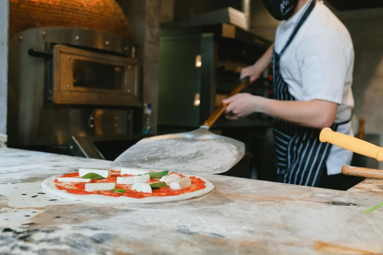 a person preparing a pizza in a kitchen, local heroes, all marble, profile image, thumbnail