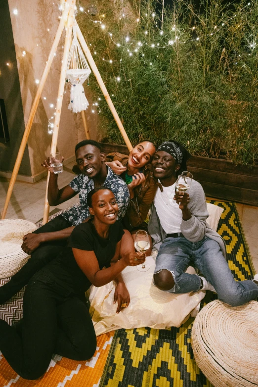 a group of people sitting on top of a rug, a picture, adut akech, college party, terrarium lounge area, instagram photo