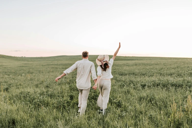 a man and a woman running through a field, pexels contest winner, romantic greenery, background image, prairie, sydney hanson