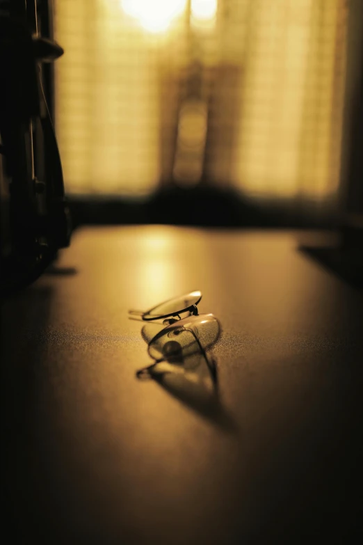 a pair of glasses sitting on top of a table, by Andrew Domachowski, ((sharp focus)), golden light, multiple stories, high angle shot