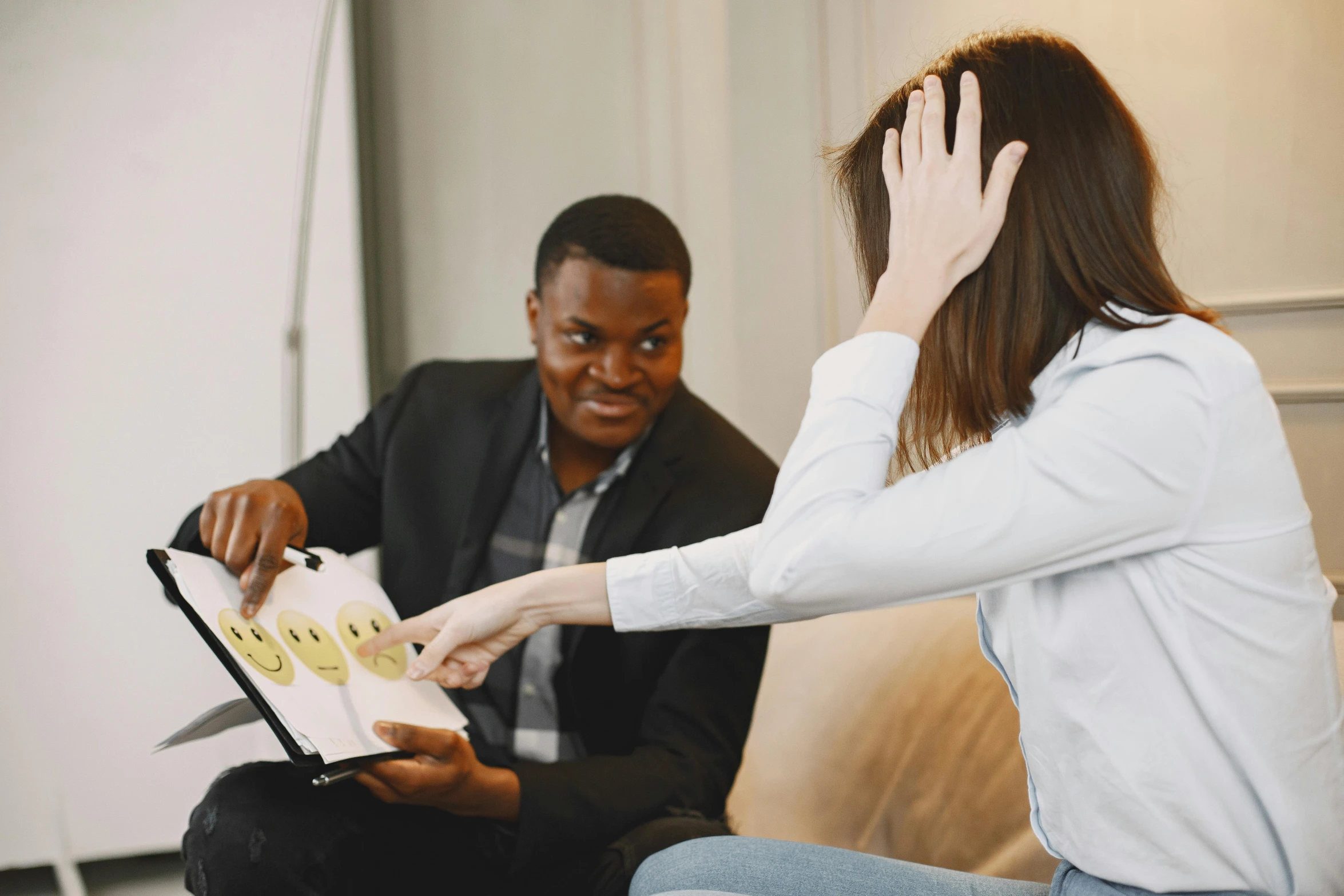 a man and a woman are sitting on a couch, convincing, working in an office, with a hurt expression, coloured photo