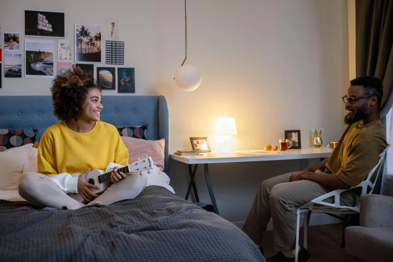 a man and woman sitting on a bed in a bedroom, connectivity, music being played, small and cosy student bedroom, profile image