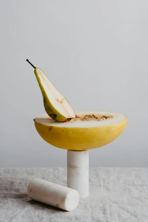 a pear sitting on top of a banana split in half, a marble sculpture, by Quinton Hoover, professional product photo, bowl, pedestal, stems