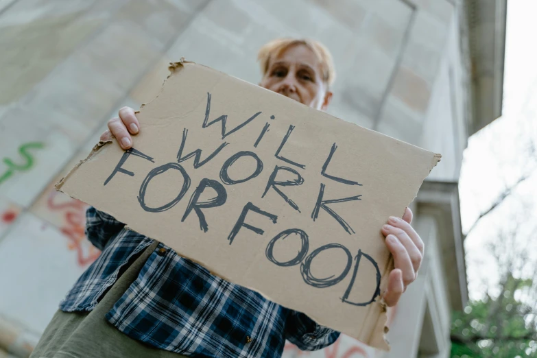 a woman holding a sign that says will work for food, a photo, trending on pexels, renaissance, skilled homeless, avatar image, food, adult