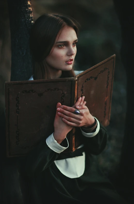 a woman holding a book in her hands, a character portrait, inspired by Anka Zhuravleva, unsplash contest winner, renaissance, ((dark fantasy)), 🤤 girl portrait, casting spells, solemn expression