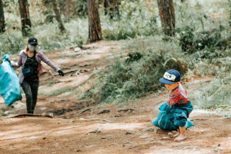 a couple of people that are walking in the dirt, by Emma Andijewska, unsplash, fine art, kids playing, pine forest, crouching, colored analog photography