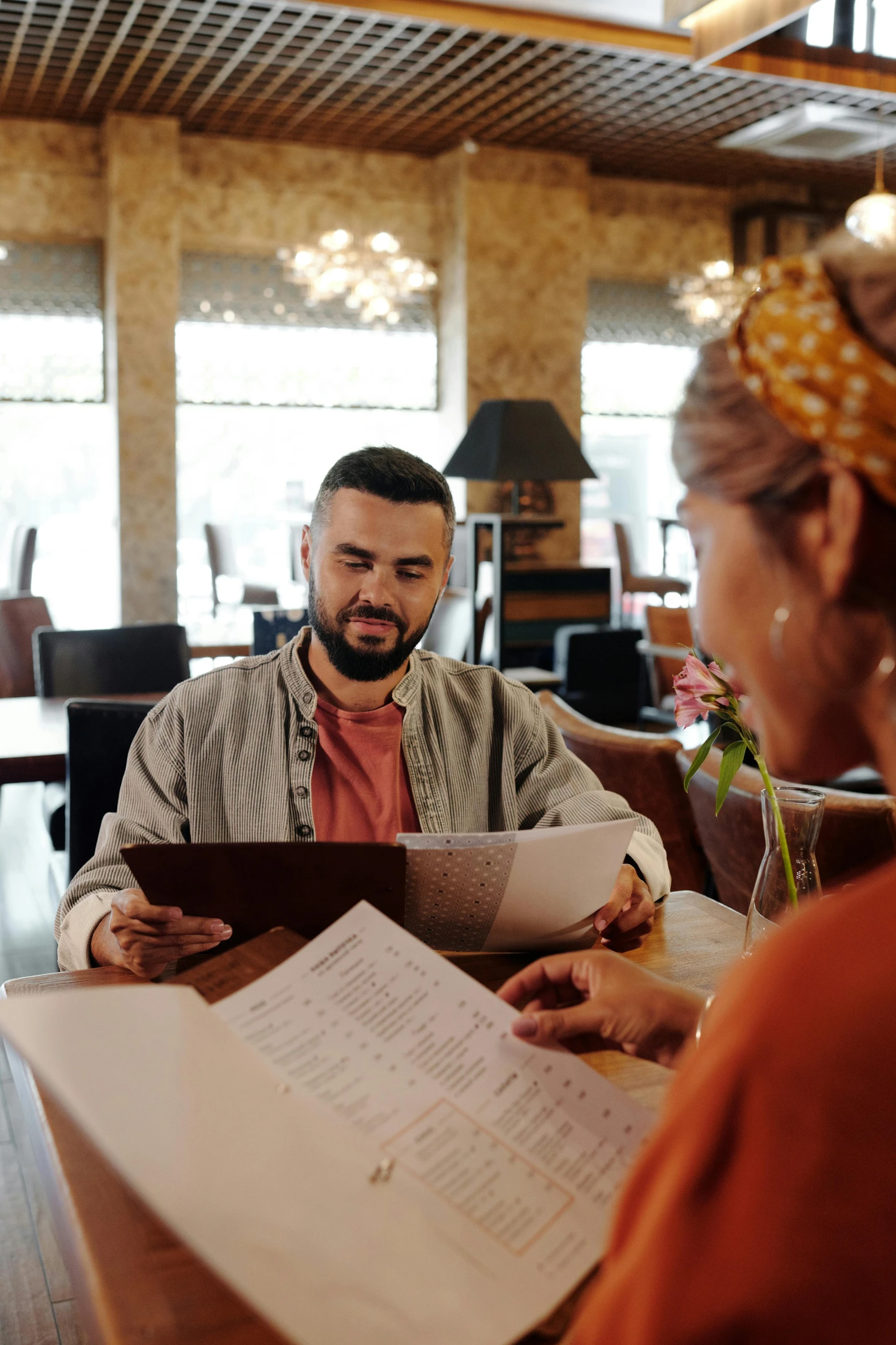 a man and woman sitting at a table with papers, pexels contest winner, renaissance, standing in a restaurant, lgbtq, islamic, 15081959 21121991 01012000 4k