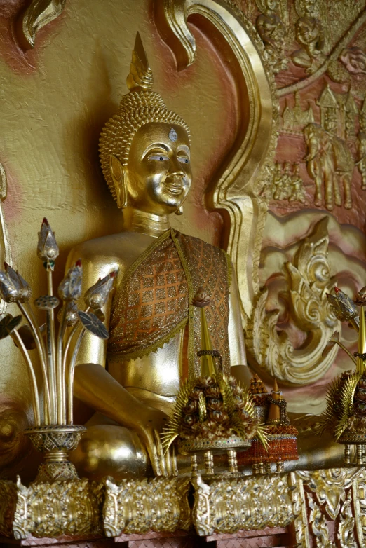 a gold statue sitting on top of a table, in a temple, on location