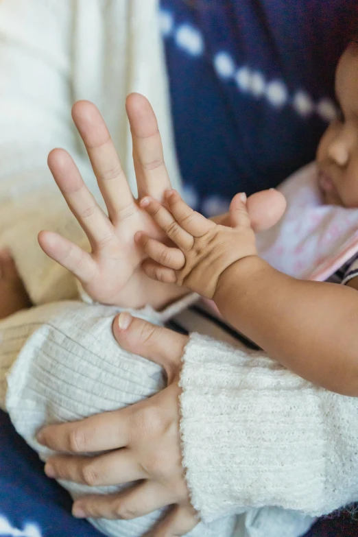 a close up of a person holding a baby, waving hands, quiet intensity, thumbnail, touch