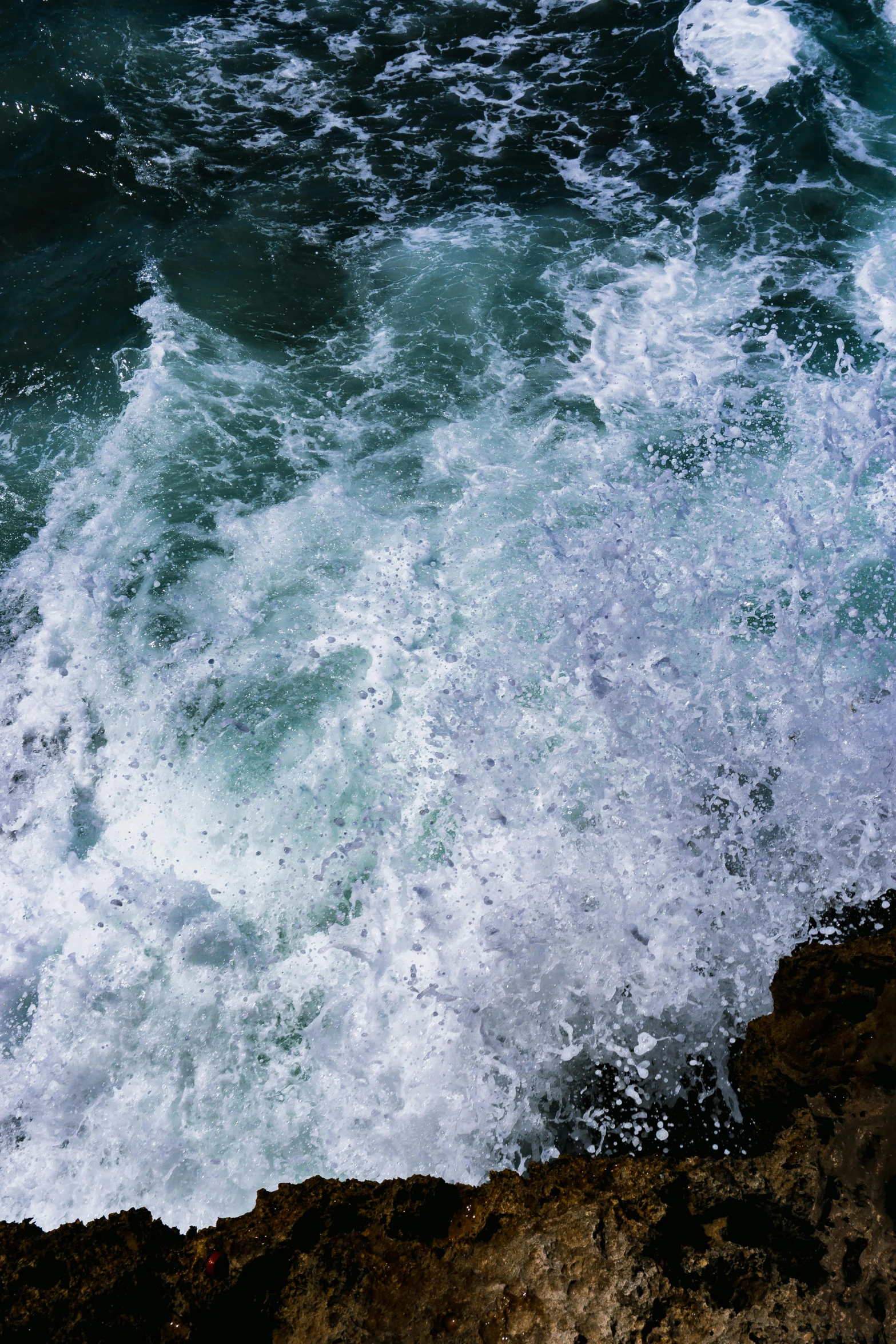 a man riding a surfboard on top of a wave, an album cover, unsplash, renaissance, waves crashing at rocks, close-up from above, immensity, glistening seafoam