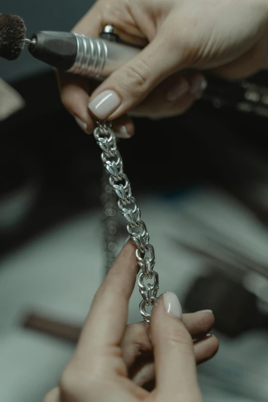 a close up of a person working on a chain, inspired by Károly Markó the Elder, chrome hearts, cinematic wide shot, amanda lilleston, carefully crafted