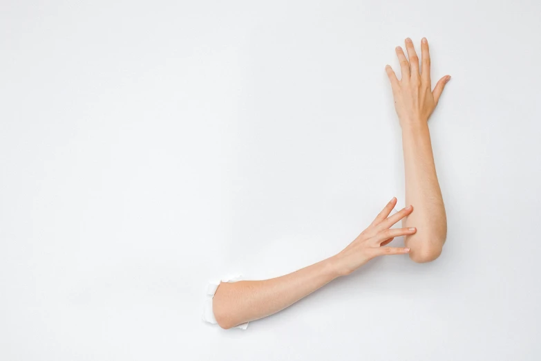 a hand reaching out of a hole in a wall, by Marina Abramović, unsplash, white backdrop, synthetic skin, skinny upper arms, ignant