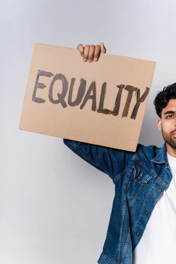 a man holding a sign that says equality, an album cover, trending on pexels, renaissance, indian, handsome male, brown, thumbnail