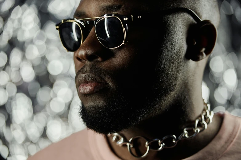 a close up of a person wearing sunglasses, inspired by Michael Ray Charles, trending on pexels, afrofuturism, gold collar, attractive man, lights on, press shot