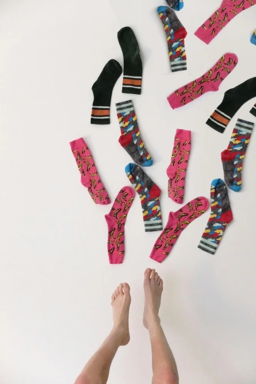 a woman standing in front of a wall covered in socks, unsplash, bird view, collection product, vibrant patterns, snacks