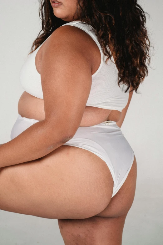 a woman in a white underwear posing for a picture, insanely inflated hips, zoomed out view, very fat, low quality photo