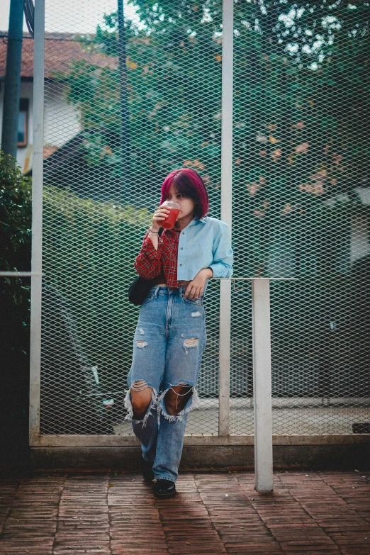 a woman leaning against a fence taking a picture of herself, a picture, inspired by Elsa Bleda, pexels contest winner, drinking boba tea, portrait full body, blue and red two - tone, ulzzang