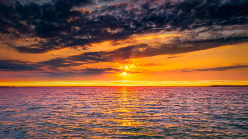 a large body of water under a cloudy sky, pexels contest winner, romanticism, bright yellow and red sun, orange / pink sky, youtube thumbnail, photo of the middle of the ocean