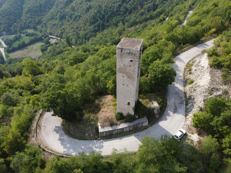 a tower sitting on top of a lush green hillside, by Francesco Furini, drone footage, square, beige, roads