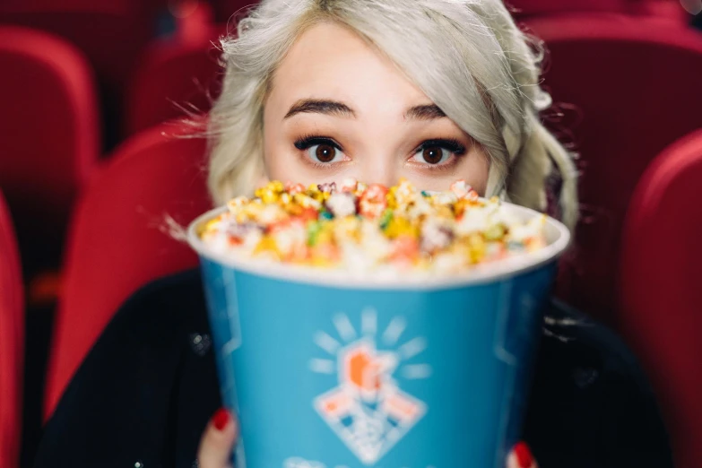 a woman holding a cup of popcorn in front of her face, inspired by Elsa Bleda, trending on reddit, sydney sweeney, holding a bucket of kfc, colourful close up shot, avatar image