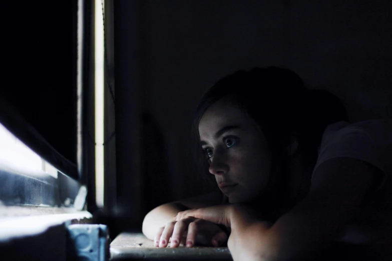 a woman sitting in front of a laptop computer, a portrait, inspired by Elsa Bleda, pexels contest winner, serial art, crewdson, film still from horror movie, girl under lantern, staring