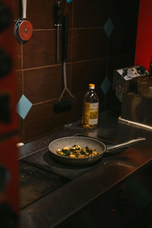 a frying pan on a stove in a kitchen, by Andries Stock, pexels contest winner, renaissance, ingredients on the table, angled shot, mid night, inside a frame on a tiled wall