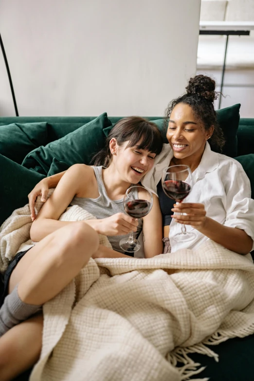 two women sitting on a couch holding wine glasses, trending on pexels, renaissance, couple on bed, happy friend, ivy's, lesbian embrace