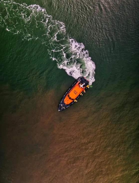 a boat in the middle of a body of water, looking down on the camera