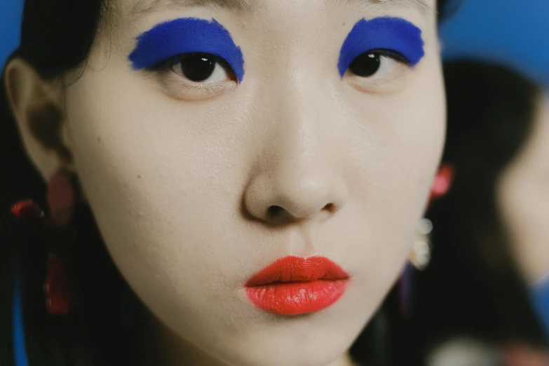 a close up of a woman with bright blue eyes, an album cover, inspired by Taro Yamamoto, trending on pexels, popular korean makeup, sangsoo jeong, lipstick, porcelain skin ”