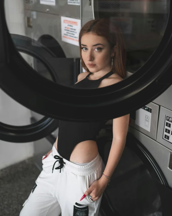 a woman standing in front of a washing machine, inspired by Elsa Bleda, trending on unsplash, renaissance, skintight black bodysuit, low quality photo, cute girl wearing tank suit, with pale skin