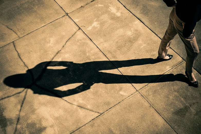 a shadow of a person walking on a sidewalk, by Bernard Meninsky, unsplash, legs intertwined, fan favorite, long shadow, two people