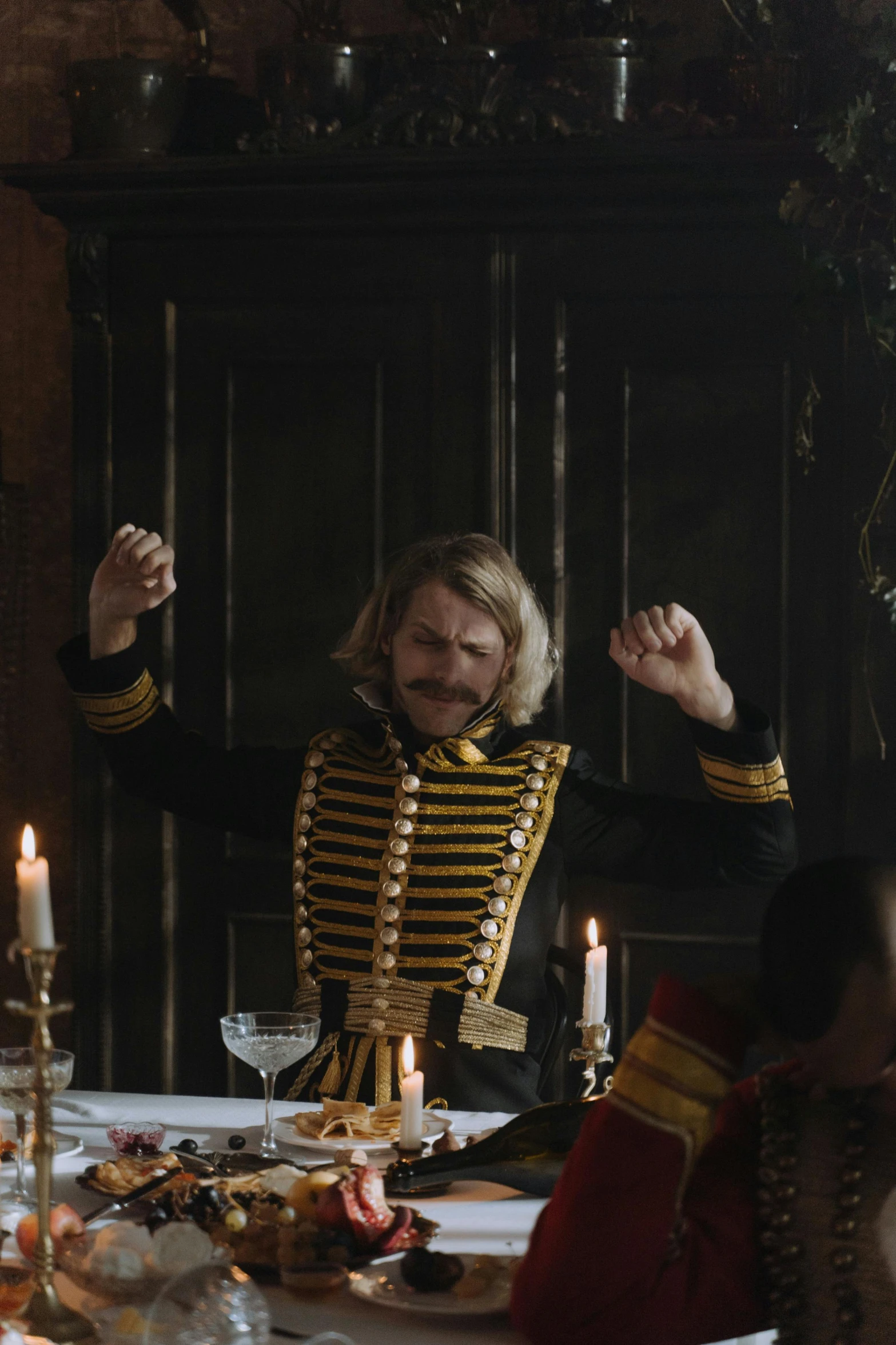 a group of people sitting around a dinner table, an album cover, inspired by Horace Vernet, unsplash, renaissance, looks like domhnall gleeson, wearing an ornate outfit, cheers, xix century military outfit