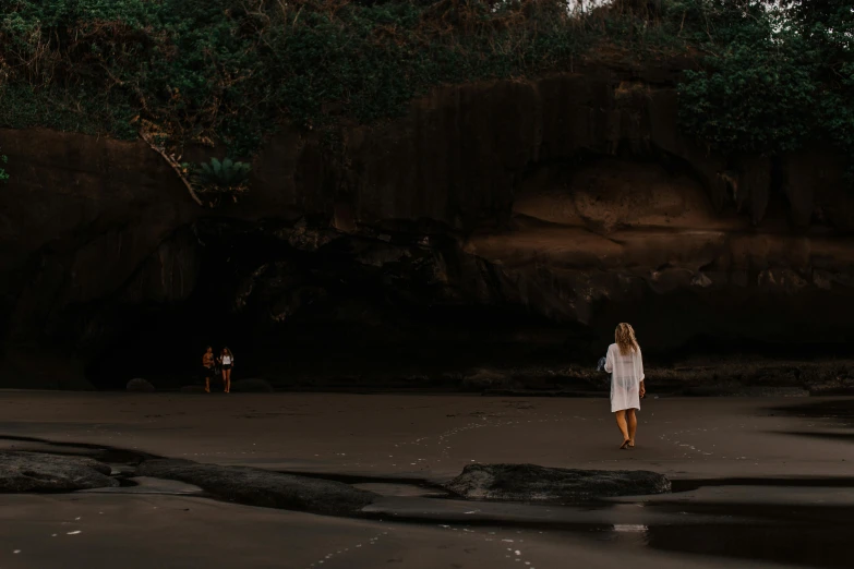 a group of people standing on top of a sandy beach, a cave painting, pexels contest winner, minimalism, girl walking in dark forest, australian beach, beach setting medium shot, huge veins