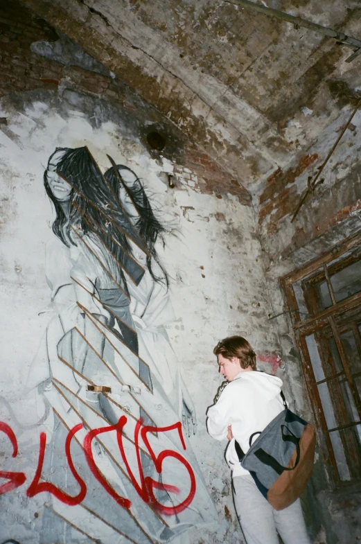 a woman standing in front of a graffiti covered wall, a painting, graffiti, inside a haunted destroyed house, yung lean, 1997 ), trip to legnica