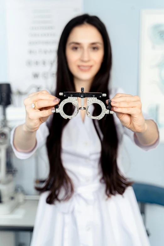 a woman in a white dress holding a pair of glasses, a picture, by Adam Marczyński, shutterstock, medical image, metal eye piece, instagram post, on display