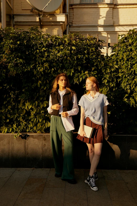 two women standing next to each other on a sidewalk, inspired by Nan Goldin, renaissance, wearing school uniform, at golden hour, ignant, gen z