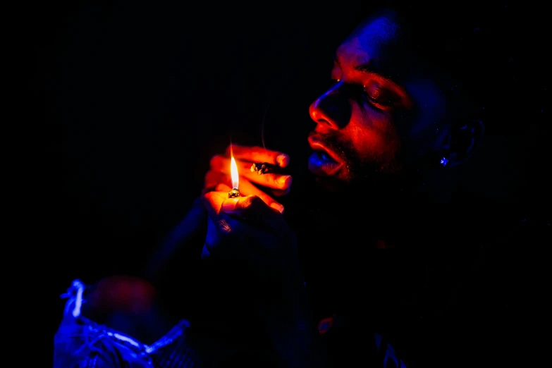 a man holding a lit candle in his hand, a portrait, by Daniel Lieske, pexels contest winner, visual art, smoking a weed with snoop dogg!!, red and blue black light, childish gambino, concentrated