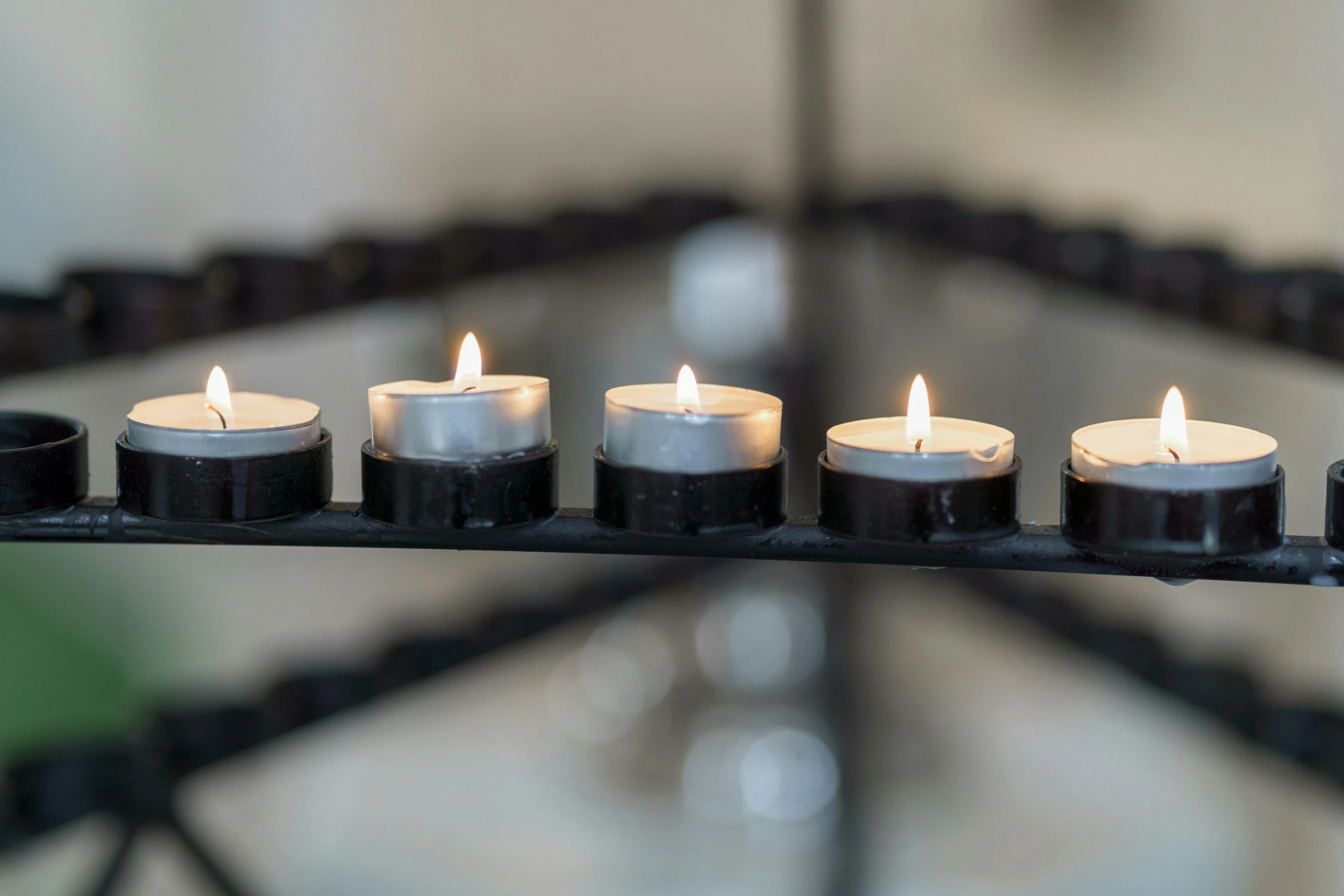 a group of lit candles sitting on top of a table, by Nina Hamnett, unsplash, minimalism, black and silver, displayed on an altar, in a row, low detail