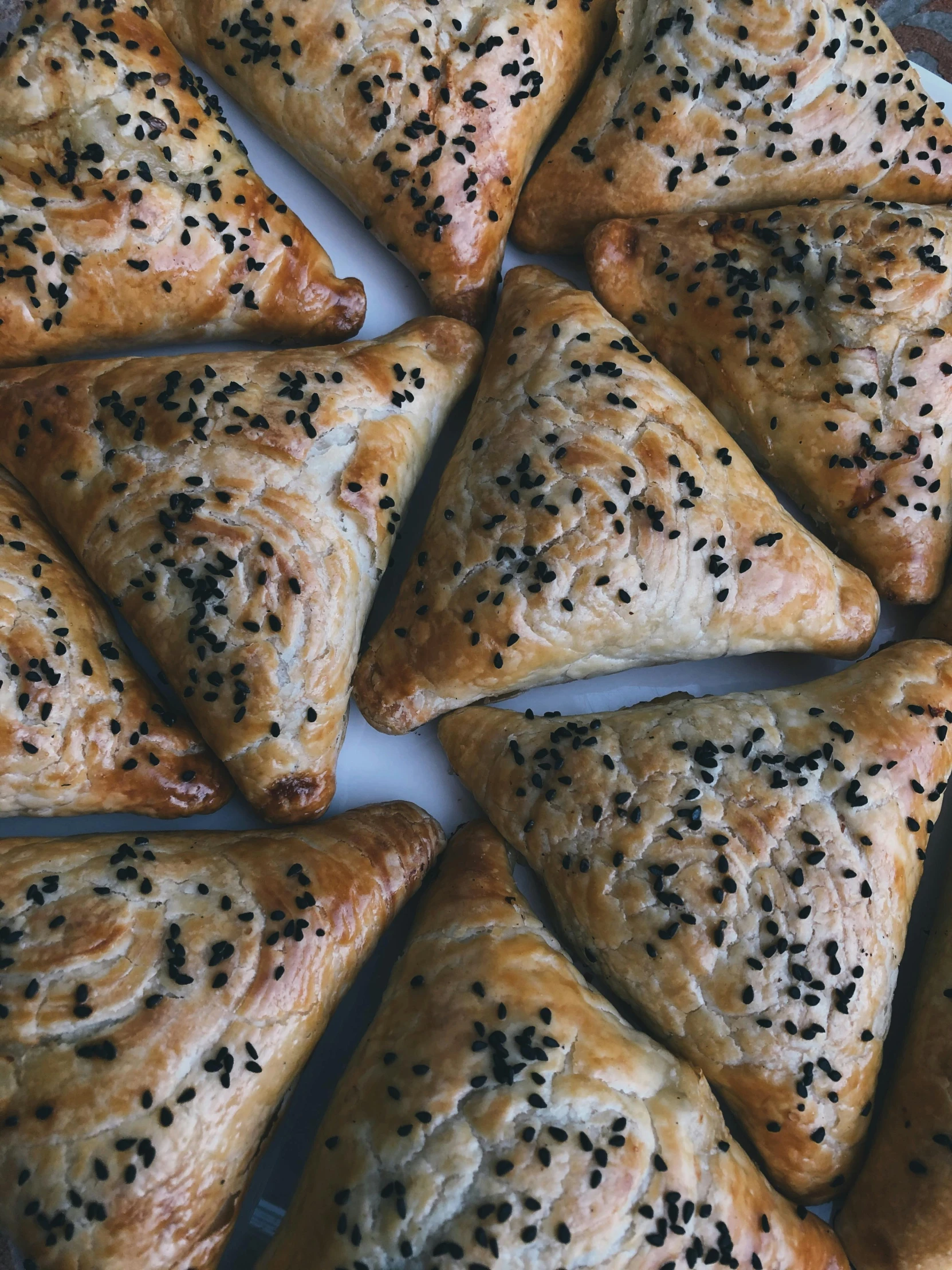 a white plate topped with lots of pastries, by Emma Andijewska, hurufiyya, in triangular formation, savory, 5k, square