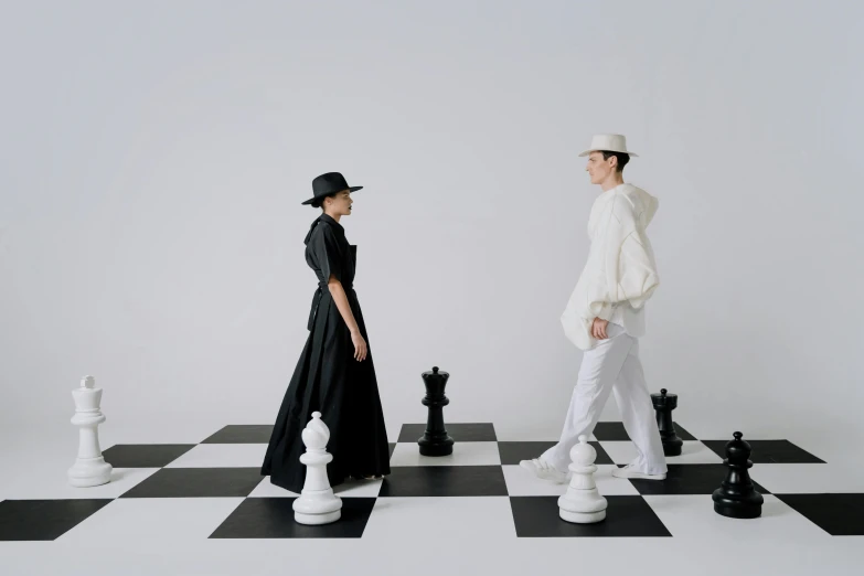 a man and a woman standing on a chess board, an album cover, inspired by Fei Danxu, unsplash, bauhaus, white suit and hat, erwin olaf, royal gown, style game square enix life