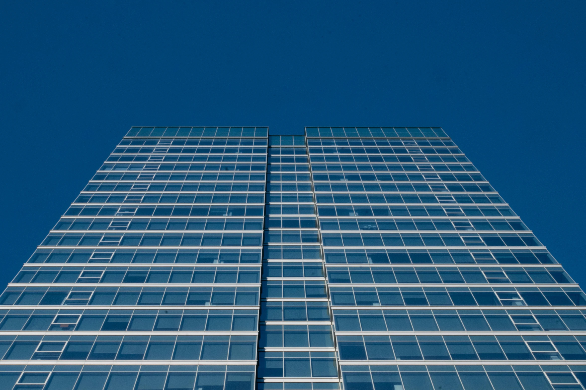 a tall glass building with a blue sky in the background, an album cover, unsplash, square, office, 1 4 9 3, painted metal and glass