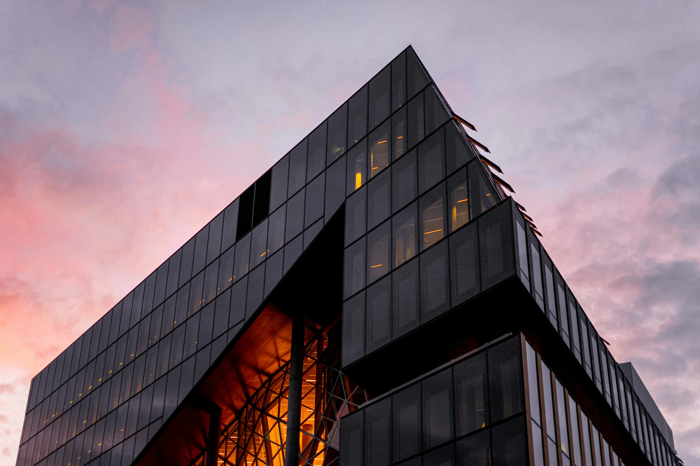 a very tall building with a lot of windows, an album cover, by Jessie Algie, unsplash contest winner, at dusk at golden hour, bjarke ingels, black steel buildings, up-angle view