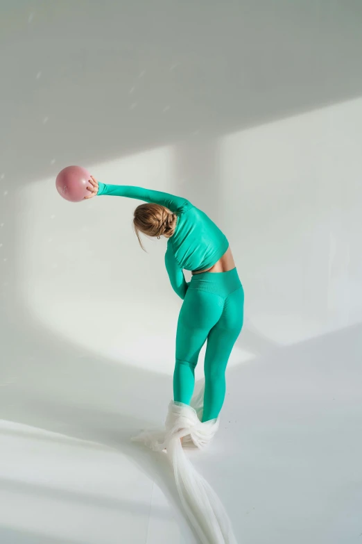 a woman in a green outfit holding a pink ball, unsplash, happening, bending over, in spandex suit, sofya emelenko, lookbook